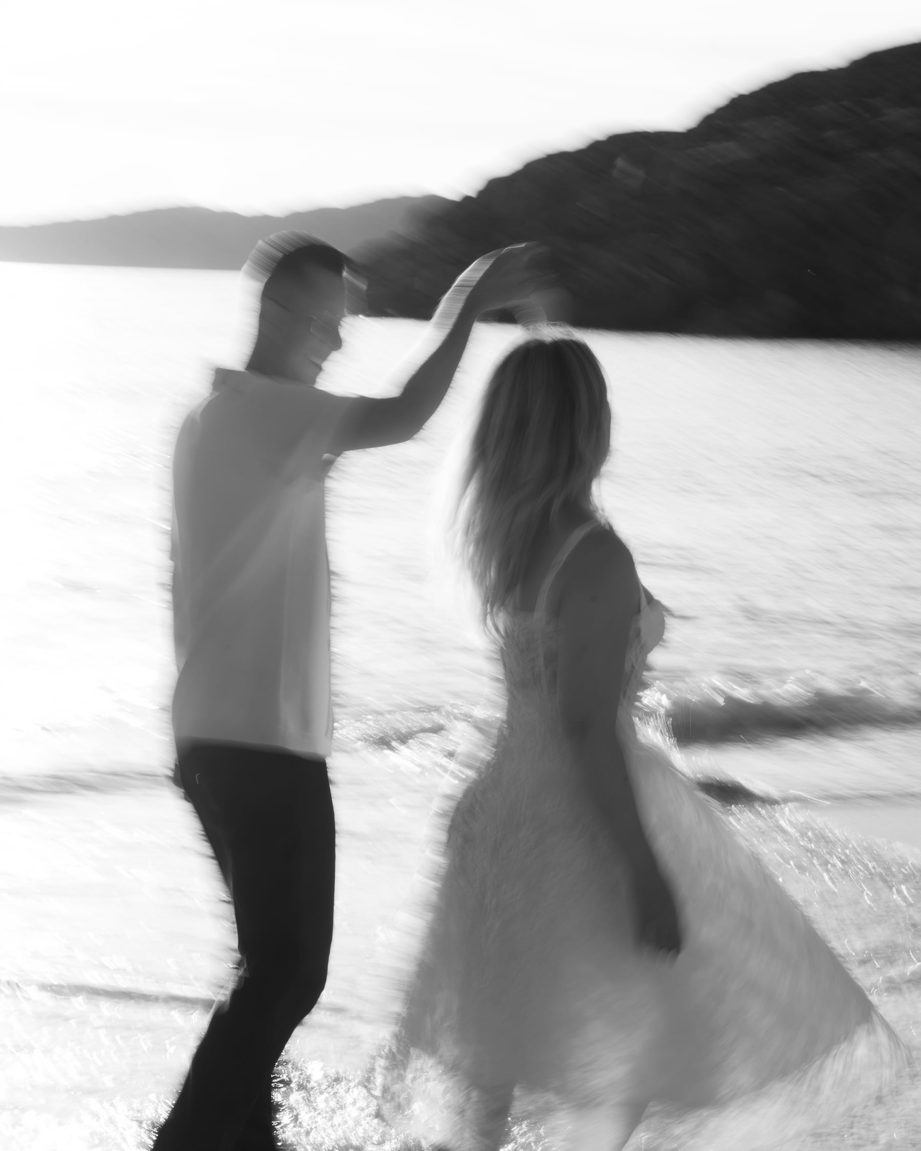 Engaged couple dancing on the beach during adventure couple session in Scotland.